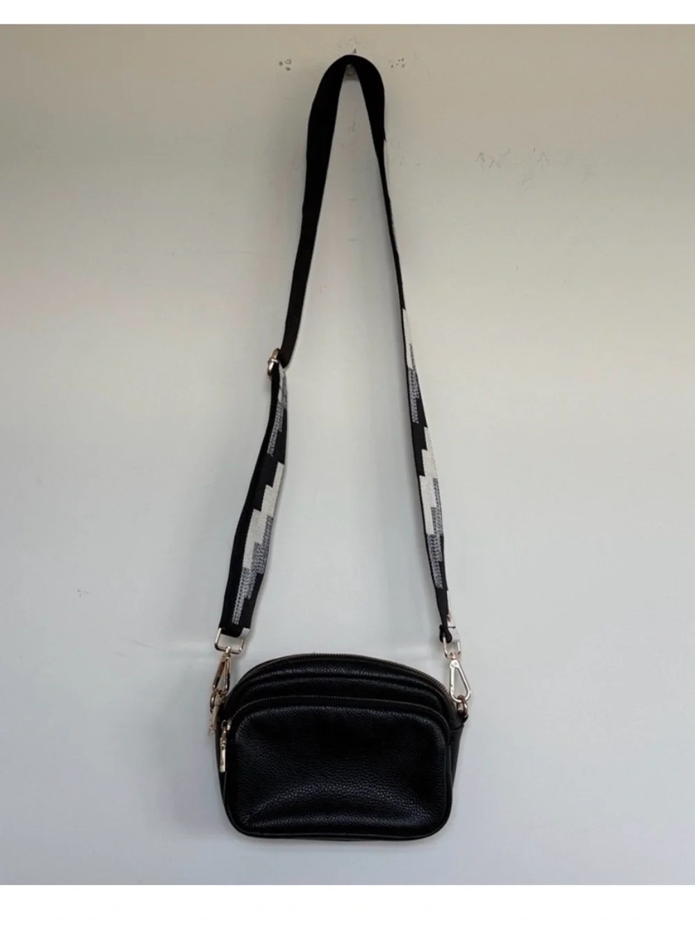Compact Black Pebble Crossbody with Patterned Strap